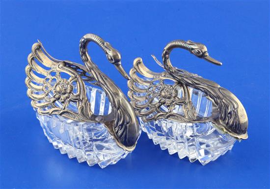 A pair of 1980s repousse silver mounted cut glass sweetmeat dishes modelled as swans, height 4in.